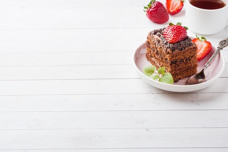 Truffle cake with chocolate and strawberries and mint on a white wooden table. Selective focus Copy spaceの写真素材