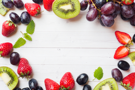 Fresh fruit strawberry kiwi grapes on white table with copy spaceの写真素材