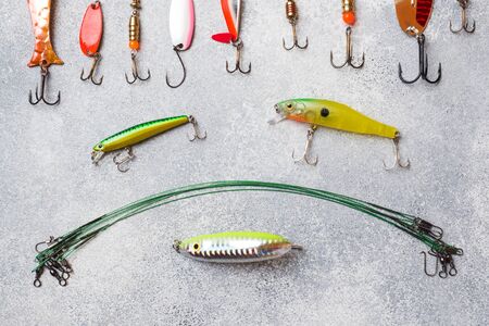 Fishing hooks and baits in a set for catching different fish on a grey background with copy space. Flat lay,の写真素材