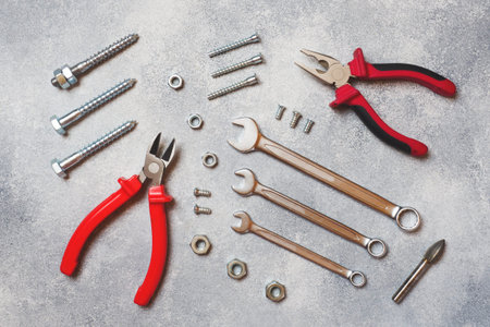 Pliers, screwdrivers and wrench combination on grey concrete background with copy space....