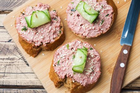 Sandwiches with chicken pate and cucumber on wooden tableの写真素材