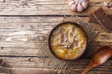 Kharcho soup with meat and rice on wooden table.の写真素材