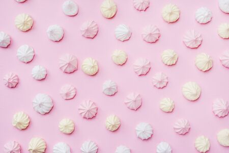 Colored small meringues on a pink background. Flat lay concept. Copy spaceの写真素材
