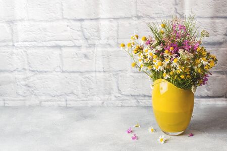 bouquet of beautiful wildflowers in vase on a gray background with copy spaceの写真素材