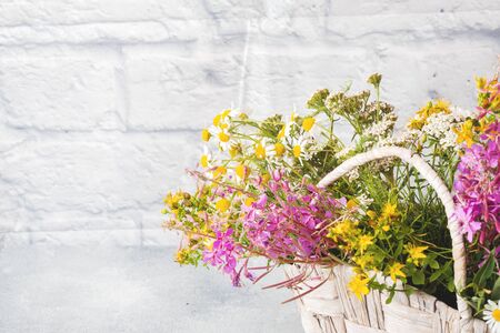 bouquet of beautiful wildflowers in a basket on a gray background with copy spaceの写真素材
