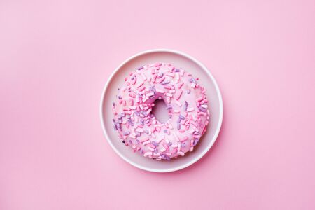 Pink doughnut on a pink background. Top view Flat layの写真素材