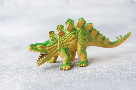 Dinosaur on a gray background. Plastic rubber toy. Selective focusの写真素材