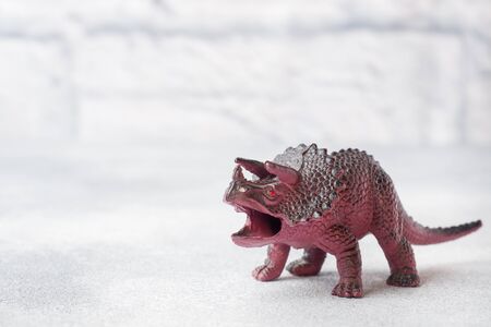 Dinosaur on a gray background. Plastic rubber toy. Selective focusの写真素材