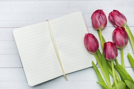 Overhead view of a bouquet of tulips and notebook. copy space. Flat lay, top view.の写真素材