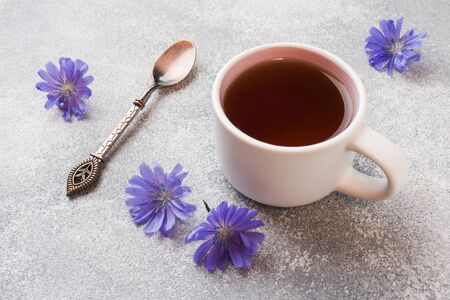 Cup with chicory drink and blue chicory flowers on grey table Copy space.の写真素材