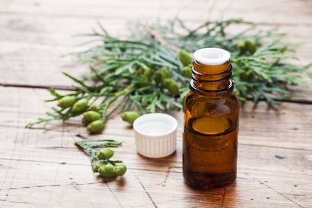 Thuja aroma essential oil in a glass jar on wooden background. Copy space. Selective focusの写真素材