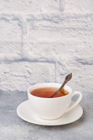 Herbal tea in a white Cup. Gray background with copy spaceの写真素材