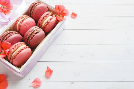 Pink dessert macaron or macaroons in a box on a white background. Copy spaceの写真素材