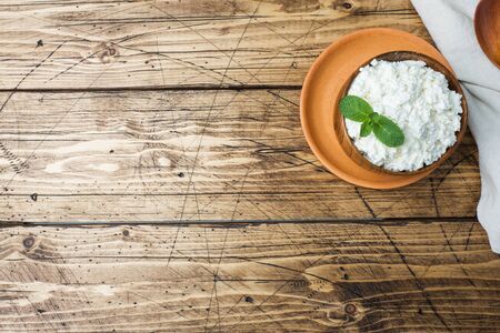 Homemade cottage cheese with mint in a bowl on old wooden table Copy space.の写真素材