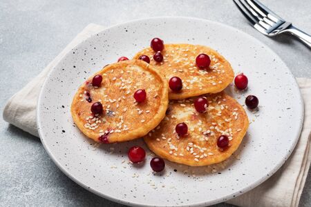 Cottage cheese pancakes with cranberries. Russian syrniki or sirniki, cottage cheese fritters or pancakes on the plateの写真素材