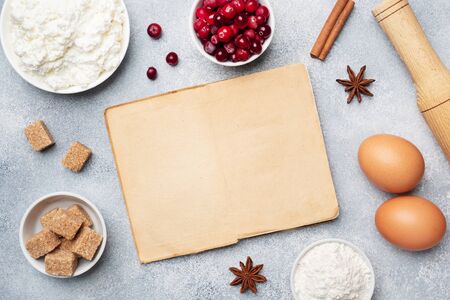 Ingredients for baking cookies, cupcakes and cake. Frame of Raw foods eggs flour sugar cottage cheese cranberries on a grey background with copy spaceの写真素材