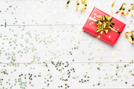 Gift boxes with gold ribbons and bows, confetti stars on a white background. Copy space Flat lay. Greeting card for birthday party, Christmas Wedding mother's Dayの写真素材