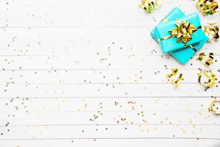Gift boxes with gold ribbons and bows, confetti stars on a white background. Copy space Flat lay. Greeting card for birthday party, Christmas Wedding mother's Dayの写真素材