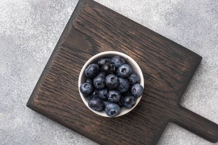 Fresh blueberries in a plate on a wooden standの写真素材