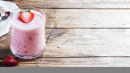 Homemade yogurt with fresh strawberries in glasses on a wooden background. Selective focus. Copy spaceの写真素材