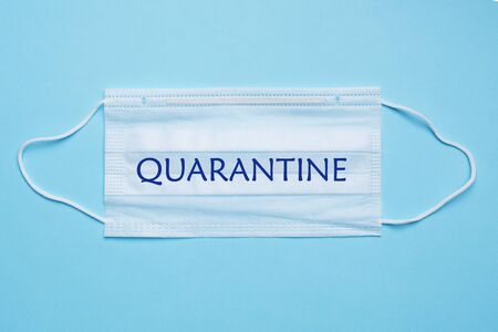 Disposable medical face masks. The concept of prevention of the virus. Blue background. Inscription Quarantinesの写真素材