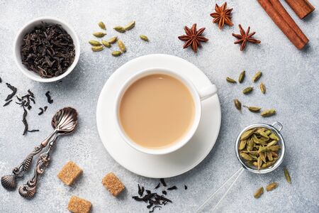 Indian drink masala tea with milk and spices. Cardamom sticks cinnamon star anise cane sugar.の写真素材