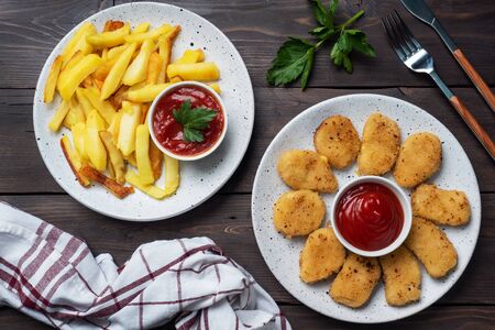 Fried potatoes and chicken nuggets with tomato ketchup sauce. Fast food concept of unhealthy food.の写真素材