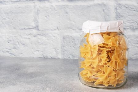 Dry pasta in a glass jar. Copy space. Concept of food storage, donationsの写真素材