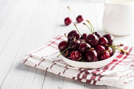 Ripe juicy cherry berries on a plate. White background. Copy space.の写真素材