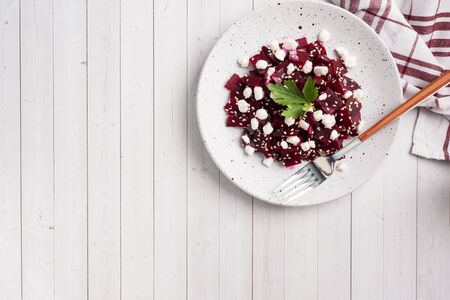 Salad of boiled beetroot and grain curd with sesame seeds on a plate. Copy spaceの写真素材