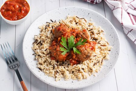 Beef meatballs and brown rice on a plate.の写真素材