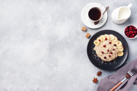 Oatmeal with milk with banana cranberries and sesame seeds. A Cup of coffee, healthy Breakfast...