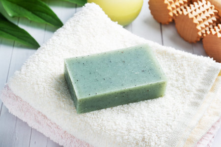 Concept SPA and Wellness. Massage brush, cosmetic oils and soap. Light background with green leaf