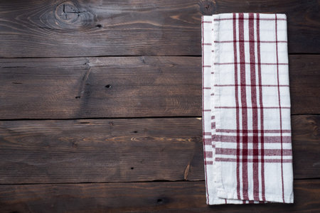 Textile napkin kitchen towel. Wooden rustic table background. Copy space