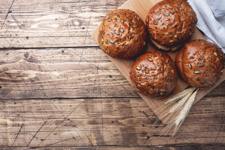 Bread products with cereals and seeds on a wooden background. Lean healthy buns, carbohydrate...