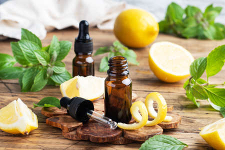 Lemon citrus fruit essential oil and mint, aromatherapy oil natural organic cosmetic on rustic wood backgroundの写真素材