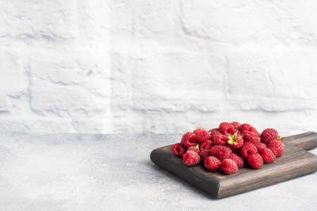 A pile of fresh juicy raspberries on a wooden Board, copy spaceの写真素材
