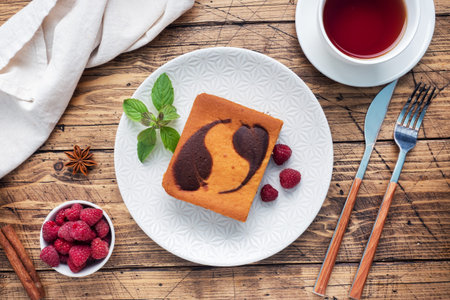 A piece of double-layer cake on a plate of chocolate brownies and curd cheesecake with raspberries...