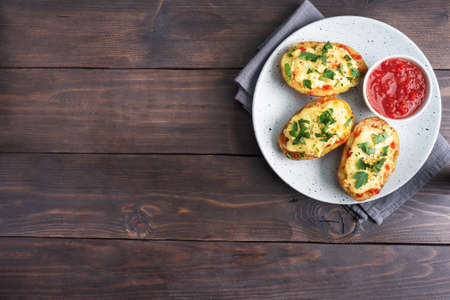 Baked potatoes in the peel stuffed with cheese with garlic and herbs Copy spaceの写真素材