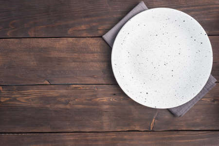 Empty white plate on wooden rustic background. Top view with copy spaceの写真素材