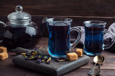 Thai blue tea anchan of buds klitoria Ternate in a glass cup, dark backgroundの写真素材