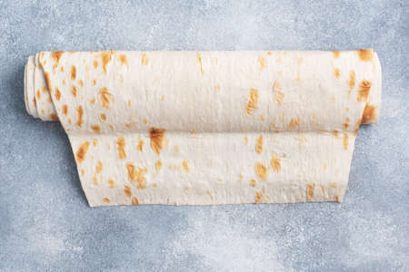 Thin Armenian lavash rolled into a roll. Texture of natural bread bakingの写真素材