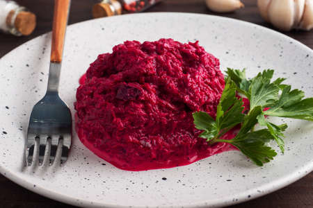 Salad of grated beetroot pine nuts and parsley with cream sauce on a plateの写真素材