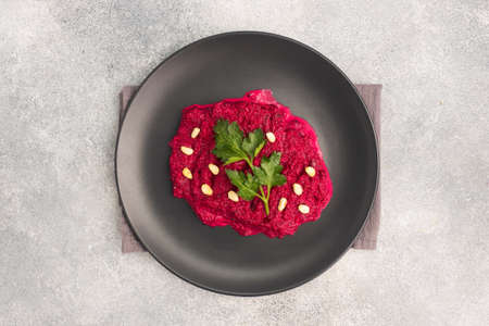 Salad of grated beetroot pine nuts and parsley with cream sauce on a plate top view copy spaceの写真素材