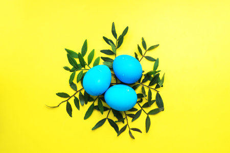 Easter eggs painted by hand colored on a yellow table, top view, copy spaceの写真素材