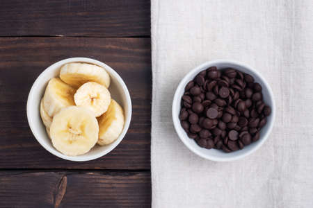 Slices of sliced banana and chocolate drops in a plate Ingredients for dessert, conceptの写真素材