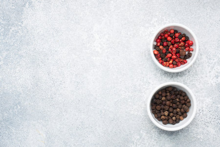 Pepper peas black and red in plates, gray concrete background copy space