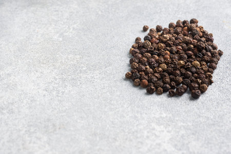 Black pepper peas on a gray concrete background, copy space
