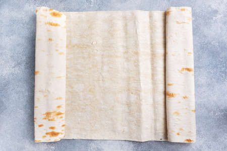Thin Armenian lavash rolled into a roll. Texture of natural bread bakingの写真素材