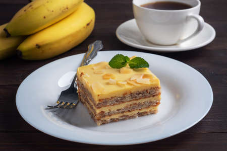 Banana sponge cake with nuts and mint. Delicious sweet dessert for tea, Dark wooden backgroundの写真素材